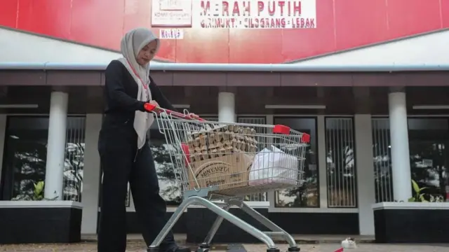 Pramuniaga mengantarkan barang kebutuhan pokok milik pembeli di Koperasi Desa Merah Putih (KDMP) Girimukti, Kabupaten Lebak, Banten, Rabu (24/9/2025).