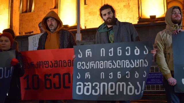 Активисты держат плакат с надписью: "Не будет декриминализации, не будет мира"