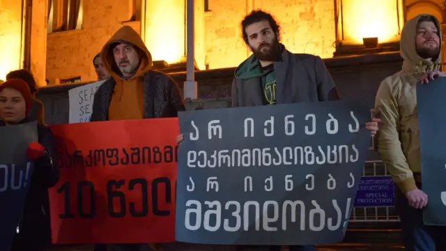 Активисты держат плакат с надписью: "Не будет декриминализации, не будет мира"