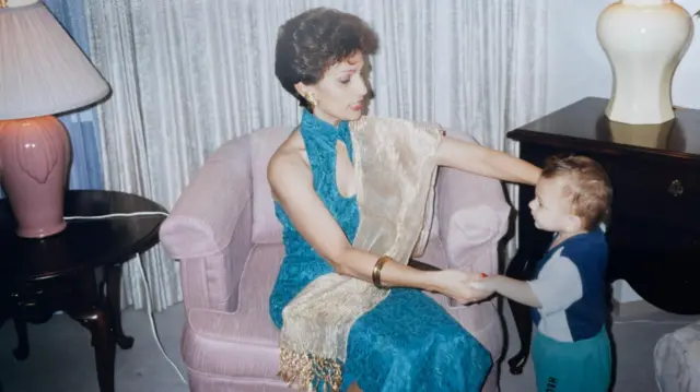 Anita agarra de la mano a Christopher cuando era niño.