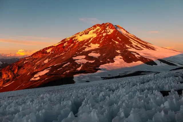 Montaña al fondo y nieve en primer plano.