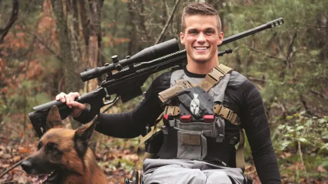 Image of candidate Madison Cawthorn showing him dressed for hunting with large gun and dog (image released by his campaign)