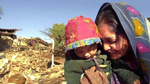 26 જાન્યુઆરી 2001ના દિવસે આવેલા ભૂકંપ બાદ 27 જાન્યુઆરીએ ભુજમાં કાટમાળ વચ્ચે દીકરીને તેડી આંસુ ઢાળતાં માતા