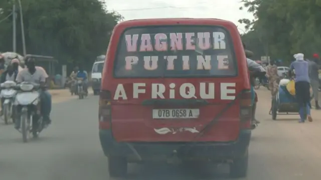 Une photo prise à travers la fenêtre d'un véhicule montre un minibus avec des lettres sur la vitre arrière, qui font référence au président russe Vladimir Poutine et au groupe paramilitaire russe Wagner, à N'Djamena - 3 septembre 2024.