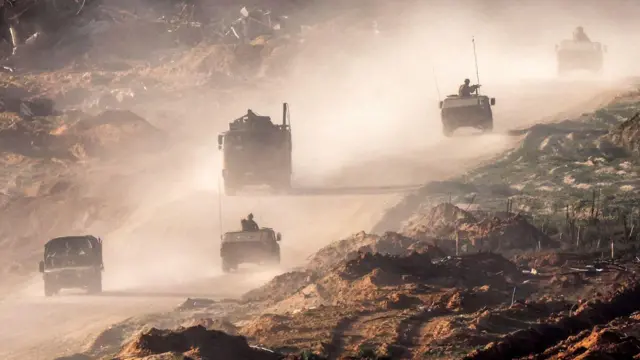 Israeli army humvees and vehicles move along a dirt road in the Gaza Strip near a position along the border with southern Israel on 4 January 2024