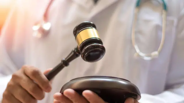 情境照片示意一名医师参与鉴定与审判。