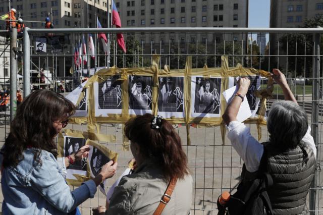 Ciudadanos chilenos en las inmediaciones del Palacio de la Moneda en Santiago para rendir homenaje a los carabineros asesinados.
