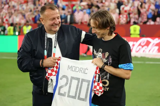 Modric'e maç sonunda üzerinde 200 sırt numarası yer alan bir hatıra forması armağan edilirken