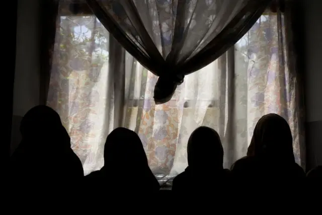 Silhouettes of girls studying in a secret school at an undisclosed location in Afghanistan