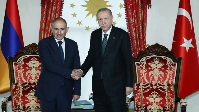 Erdoğan ve Paşinyan el sıkışyor. Arkalarında Türk ve Ermenistan bayrakları var.