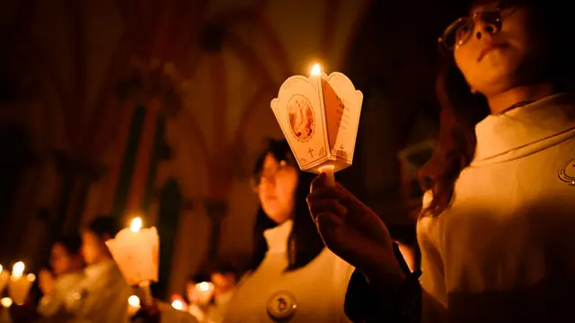 Umat Katolik di China menyalakan lilin saat misa Paskah di sebuah gereja di Beijing, 30 Maret 2024.