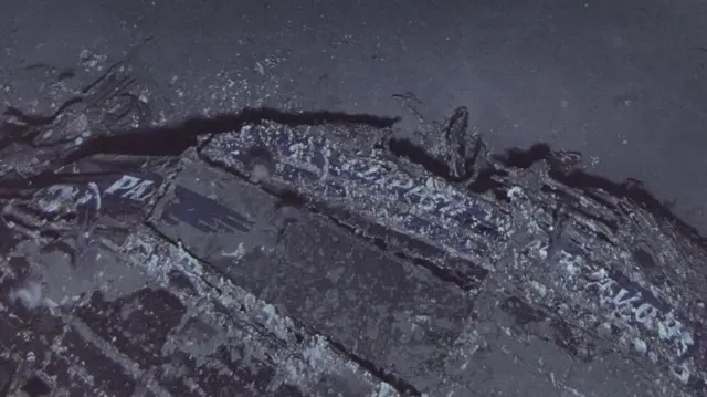 Imagem em close-up dos destroços do Clipper Endeavour mostrando o logotipo da Pan Am.