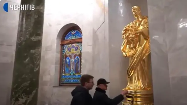 Яковишин показує журналістам одну із статуй, яку списували з нього, в його власному мавзолеї