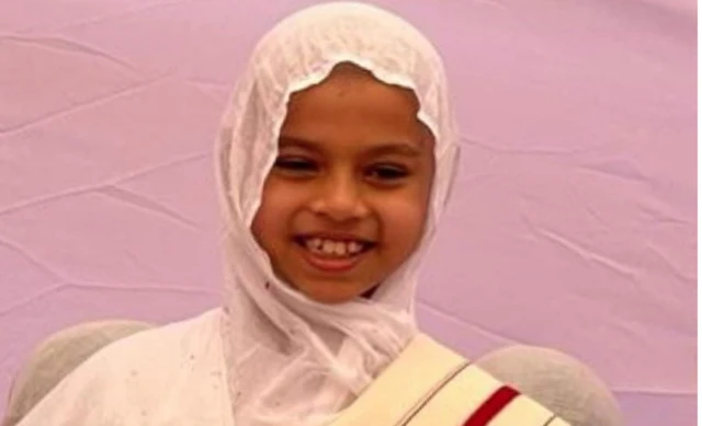 Devanshi after the ceremony, wearing a white head covering and robes