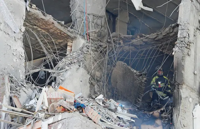 Los bomberos trabajan para apagar las llamas dentro de un edificio de apartamentos en Kiev.
