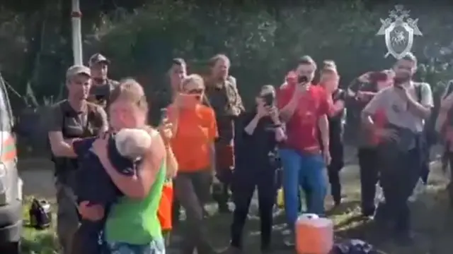 Mãe e filha se abraçam logo após Lyuda ser encontrada na floresta