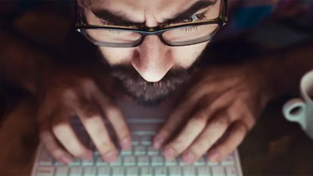 Hombre frente a la pantalla de una computadora
