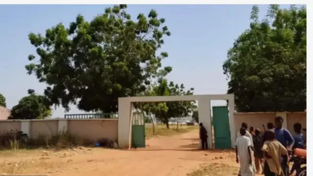 Abawọle ile ẹkọ naa pẹlu awọn ọmọdekunrin kan to duro niwaju ibẹ