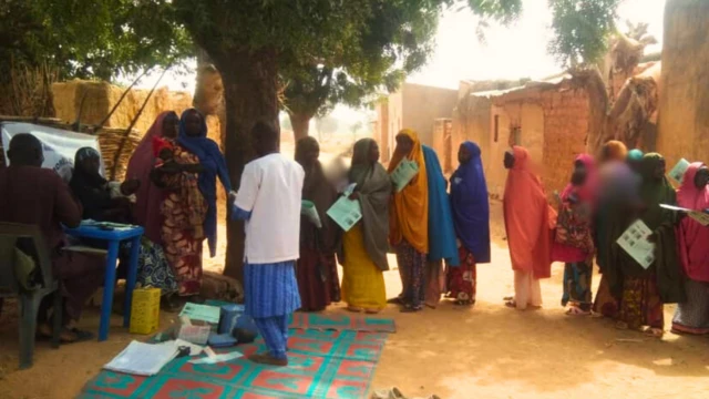 Women in Baita bring their children for vaccine