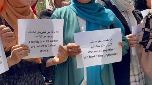 تجمع زنانی با کاغذهایی که در آن به محدودیتهای طالبان علیه زنان اعتراض شده است