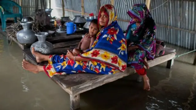 ঘরে বন্যার পানি, খাটের ওপর বসে আছে মানুষ