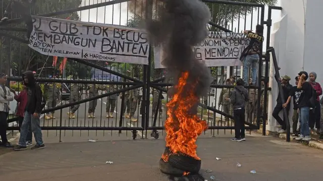 Sejumlah pelajar dan mahasiswa yang tergabung dalam Aliansi untuk Indonesia Cerdas (AIC) memasang spanduk di gerbang Kantor Gubernur Banten saat berunjuk rasa di Serang, Kamis (2/5/2024). 