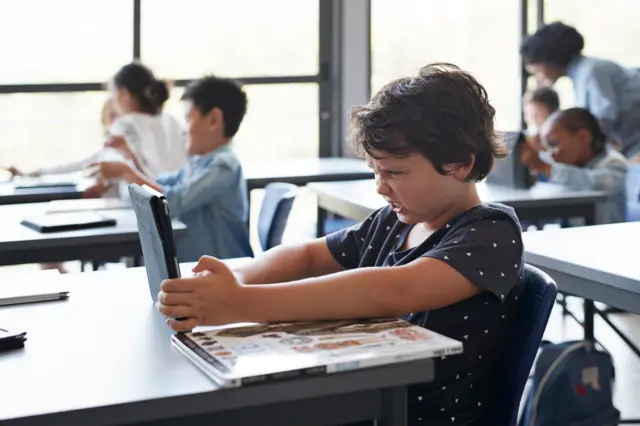 Criança com tabletaposta acima de 3.5salaaposta acima de 3.5aula