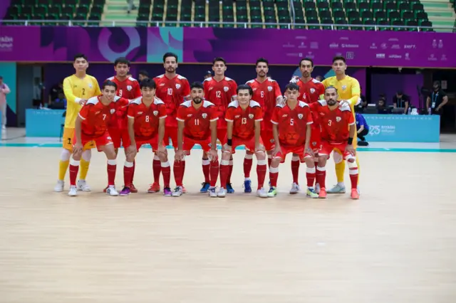 عکس دسته‌جمعی بازیکنان تیم ملی فوتسال افغانستان با لباس‌های سرخ و دروازه‌بانان با لباس زرد در رقابت‌های همبستگی کشورهای اسلامی