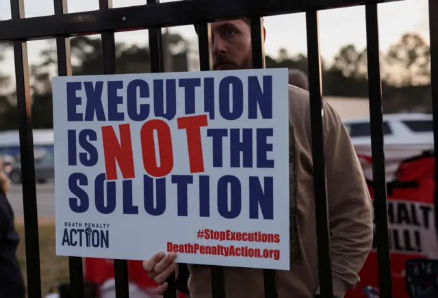 Un hombre con un cartel que dice "La ejecución no es la solución"