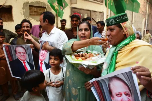 पांच अगस्त को गिरफ़्तारी के बाद इमरान ख़ान के कुछ विरोधियों ने मिठाईयां बाटीं.