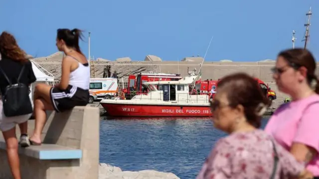 Pessoas observando as equipesanalise sportingbetresgate perto do local do naufrágio do iate