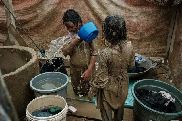 Dua anak perempuan membersihkan diri usai Aceh Tamiang dihajar banjir November 2025. 