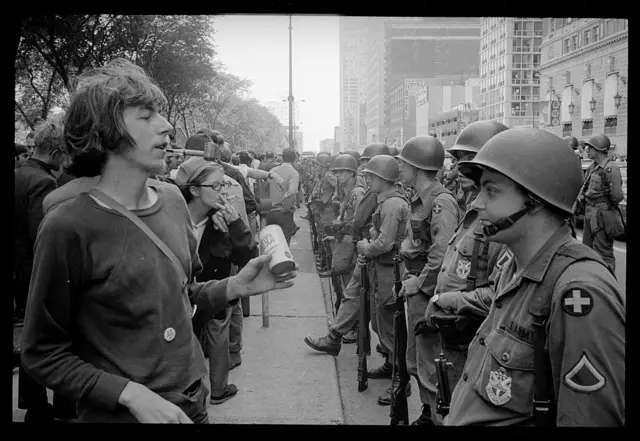 Manifestantes em frente a soldados