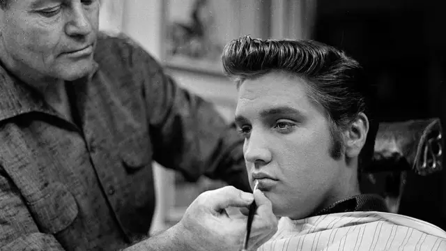 Un maquillista le aplica una pincelada de labial a Elvis Presley