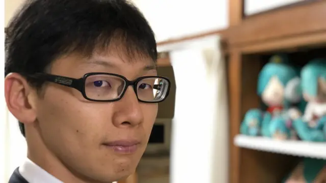 Kondo. Al fondo, una colección de muñecas de Hatsune Miku