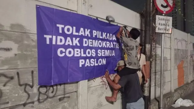 Beberapa warga yang golput memasang spanduk tolak pilkada Jakarta di seputaran Penjaringan, Jakarta Utara.