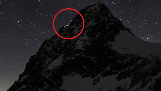 A red circle shows a torchlit climb on a mountainside in Austria