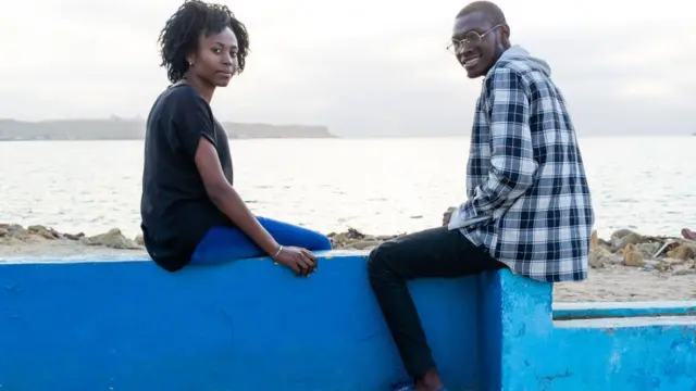 Man and woman wey siddon for beach.