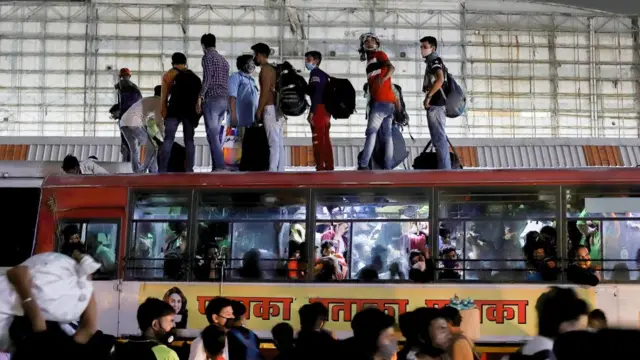 டெல்லி கெளஷம்பி பேருந்து நிலையத்தில் சொந்த ஊர்களுக்கு செல்ல பேருந்து கூரைகளை ஆக்கிரமித்த மக்கள்