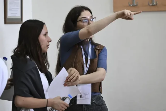 Sınav belgelerini kontrol eden bir gözetmen