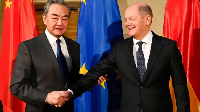 জার্মান চ্যান্সেলর ওলাফ শোলৎজের সাথে হ্যান্ডশেক করছেন ওয়াং ই।