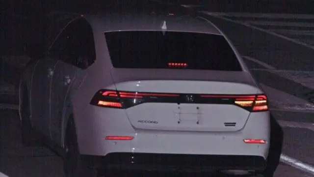 白い車を後方から捉えた画像。ナンバープレートはなく、辺りは薄暗い