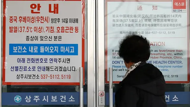 Женщина перед входом в поликлинику в городе Тэгу