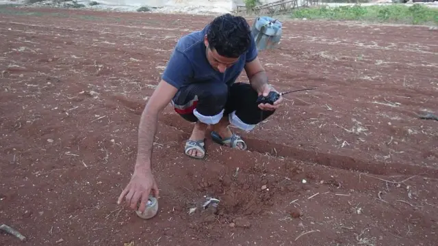 Сирієць роздивляється залишки кластерної бомби, яка належить російській армії, в житловому районі Ідліба у 2016 році