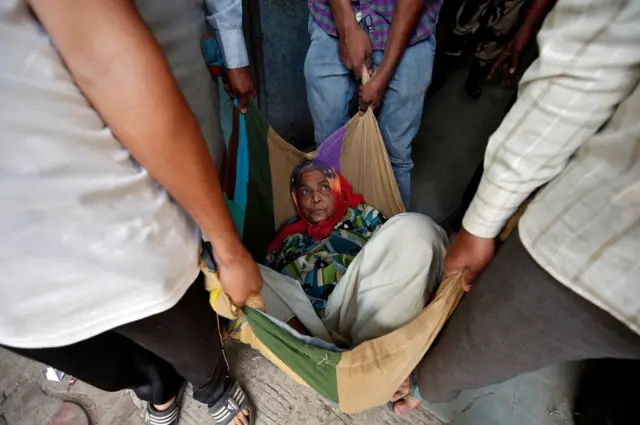 امرأة مسنة محمولة في بطانية