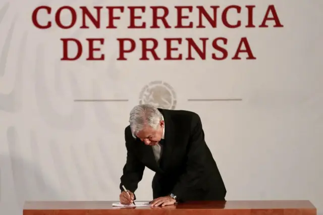 AMLO firmando el documento.