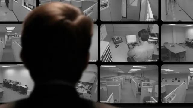 Un hombre mira varios monitores de una oficina