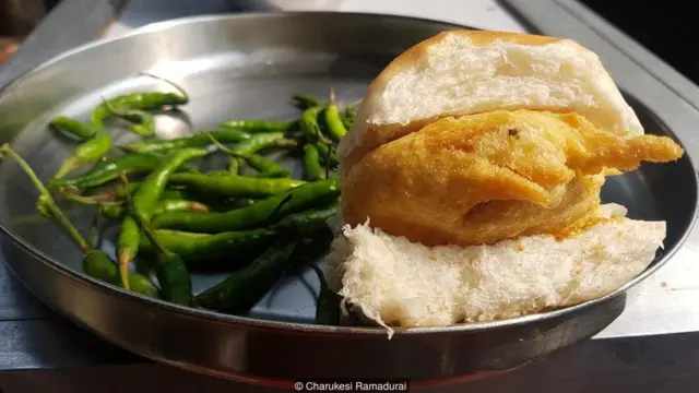 Vada pav is a deep-fried potato patty served on a soft bread roll with spicy green chilli