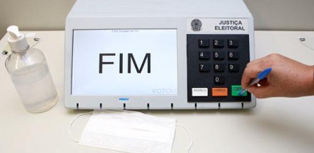 Uma mão pressiona o botão confirmapokerstars casino brasiluma urna eletrônica com uma caneta