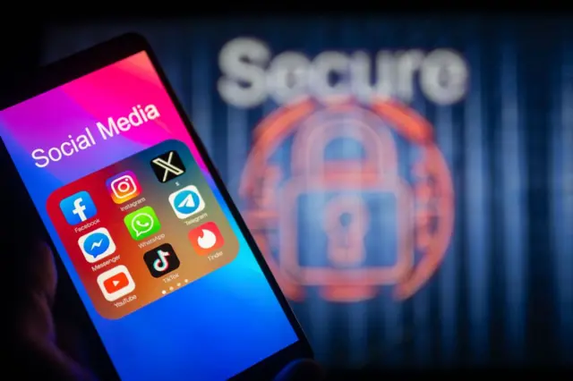 Ikon media sosial ditampilkan di ponsel pintar dengan kunci aman yang terlihat di latar belakang